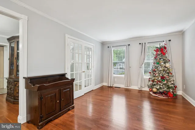 a view of an empty room with window and wooden floor