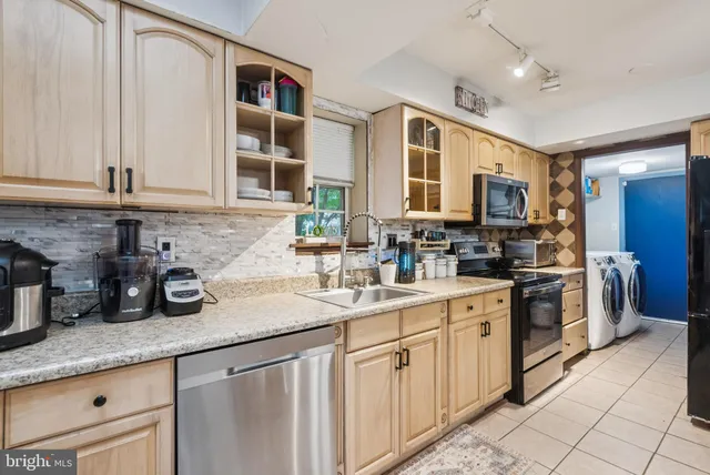 a kitchen with stainless steel appliances granite countertop a sink stove and cabinets