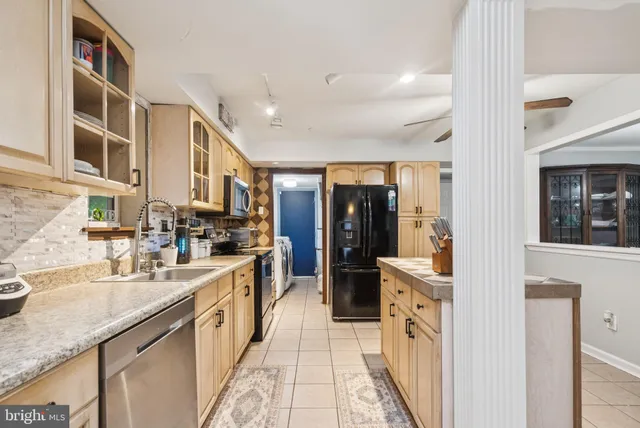 a large kitchen with stainless steel appliances granite countertop a lot of counter space and a sink