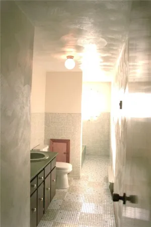 a bathroom with a granite countertop sink a toilet and mirror