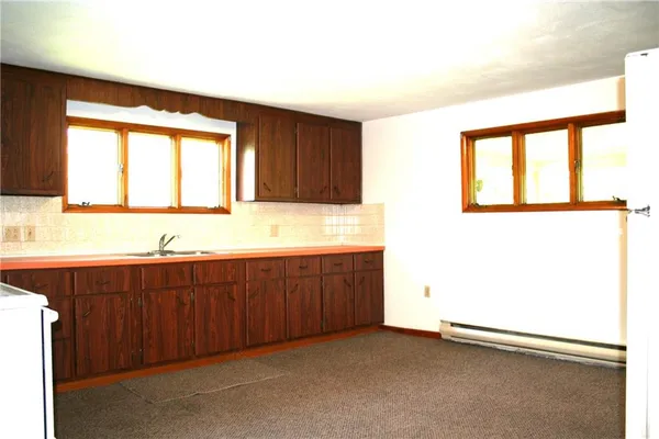 a view of a kitchen with wooden floor and a window