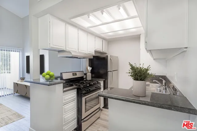 a kitchen with stainless steel appliances a sink a stove and cabinets