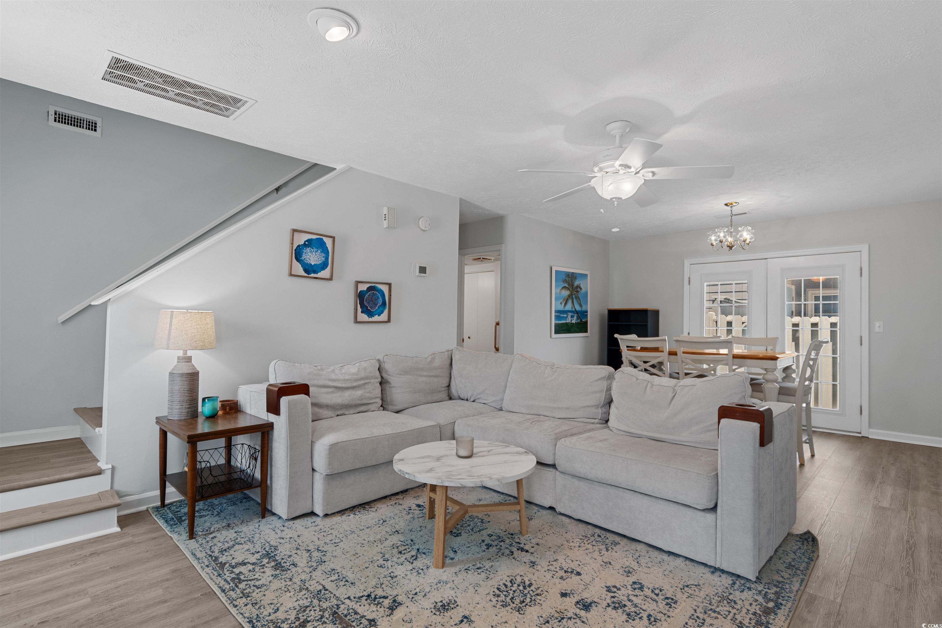 605 A 17th Avenue South North Myrtle Beach, SC 29582 - Photo 11 of 36 Living area with stairway, a ceiling fan, light wood-type flooring, and a chandelier