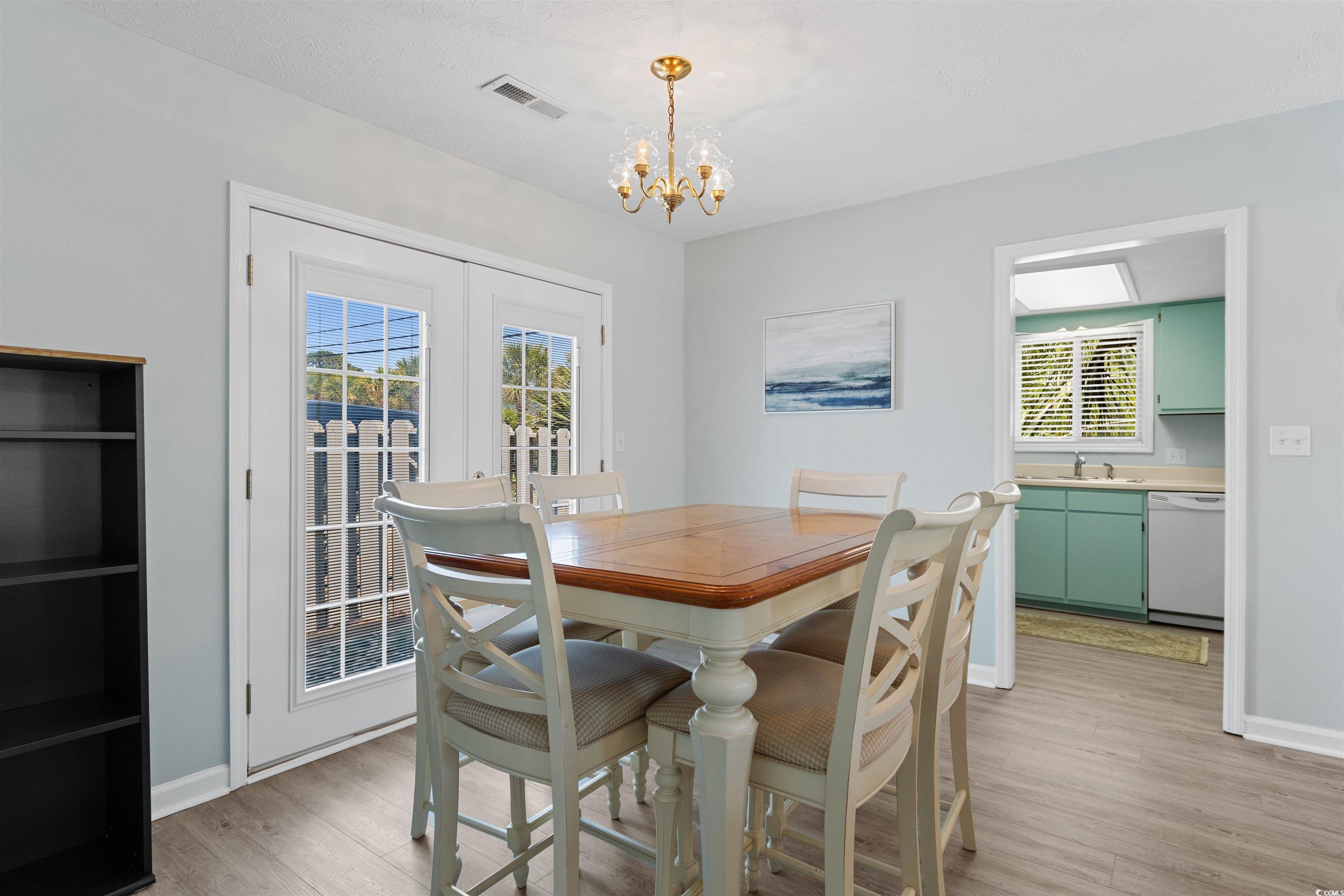 605 A 17th Avenue South North Myrtle Beach, SC 29582 - Photo 13 of 36 Dining space with light wood finished floors, a chandelier, and french doors