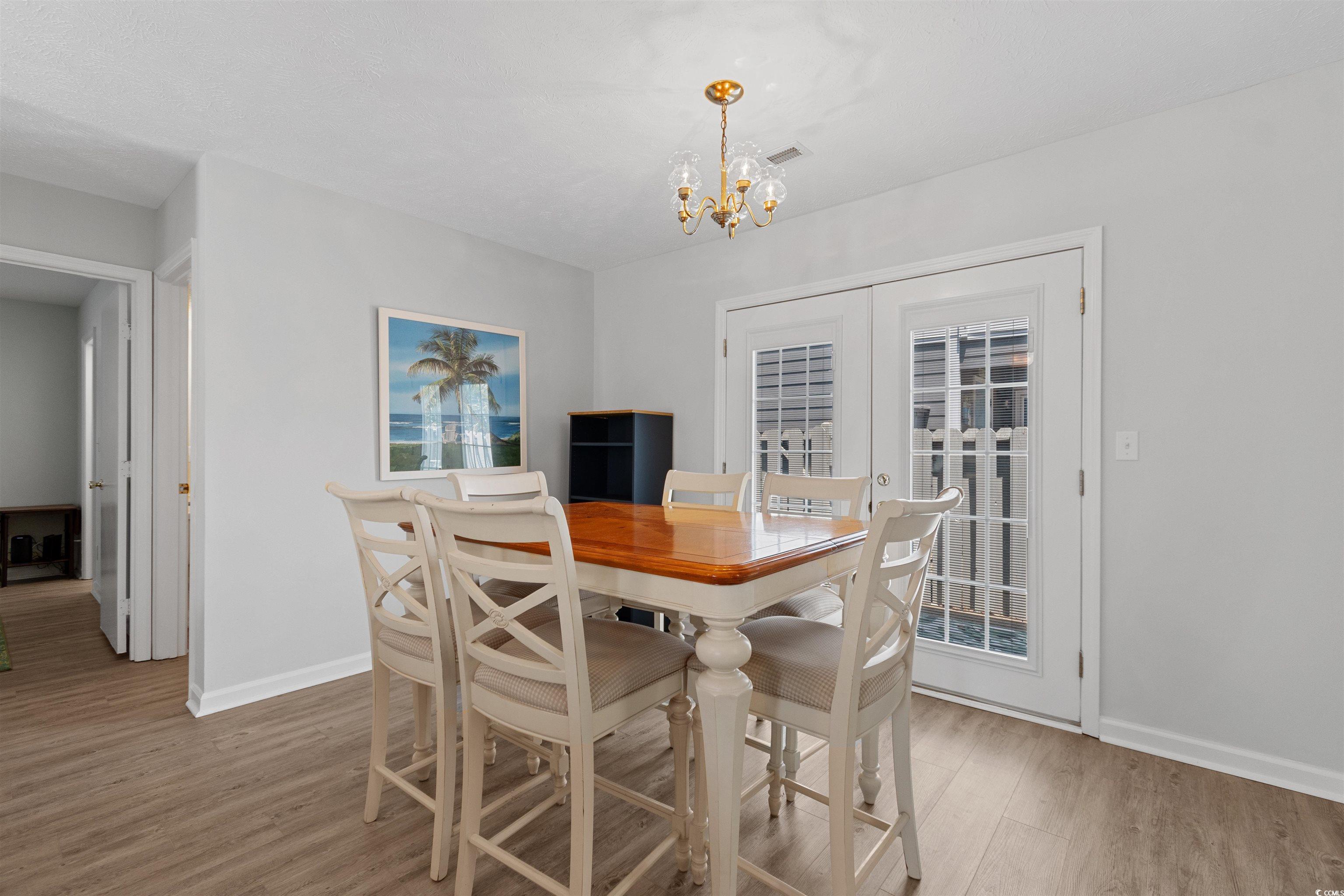 605 A 17th Avenue South North Myrtle Beach, SC 29582 - Photo 14 of 36 Dining room featuring light wood-style floors, french doors, and a chandelier