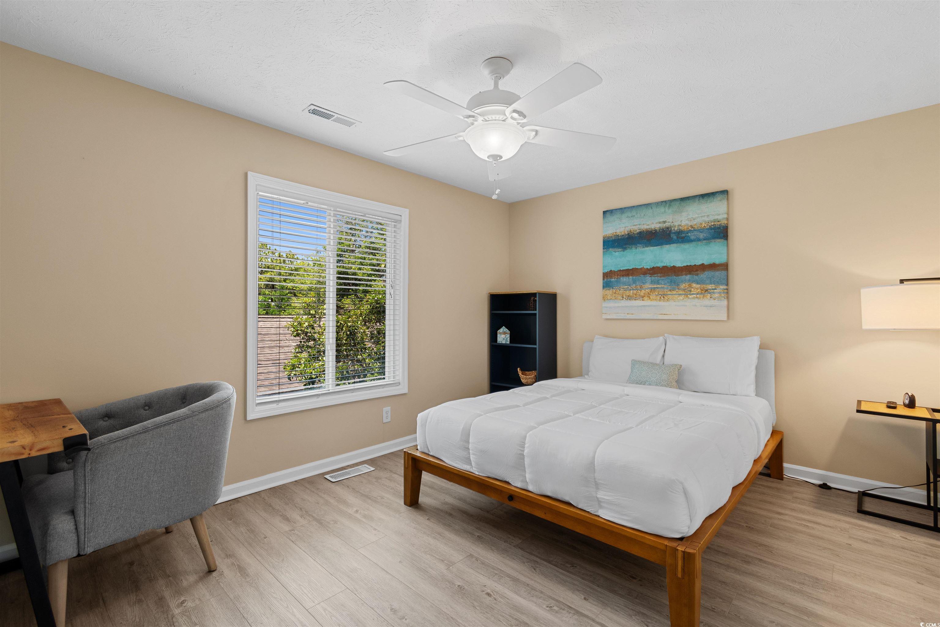 605 A 17th Avenue South North Myrtle Beach, SC 29582 - Photo 15 of 36 Bedroom with wood finished floors, a ceiling fan, and a textured ceiling