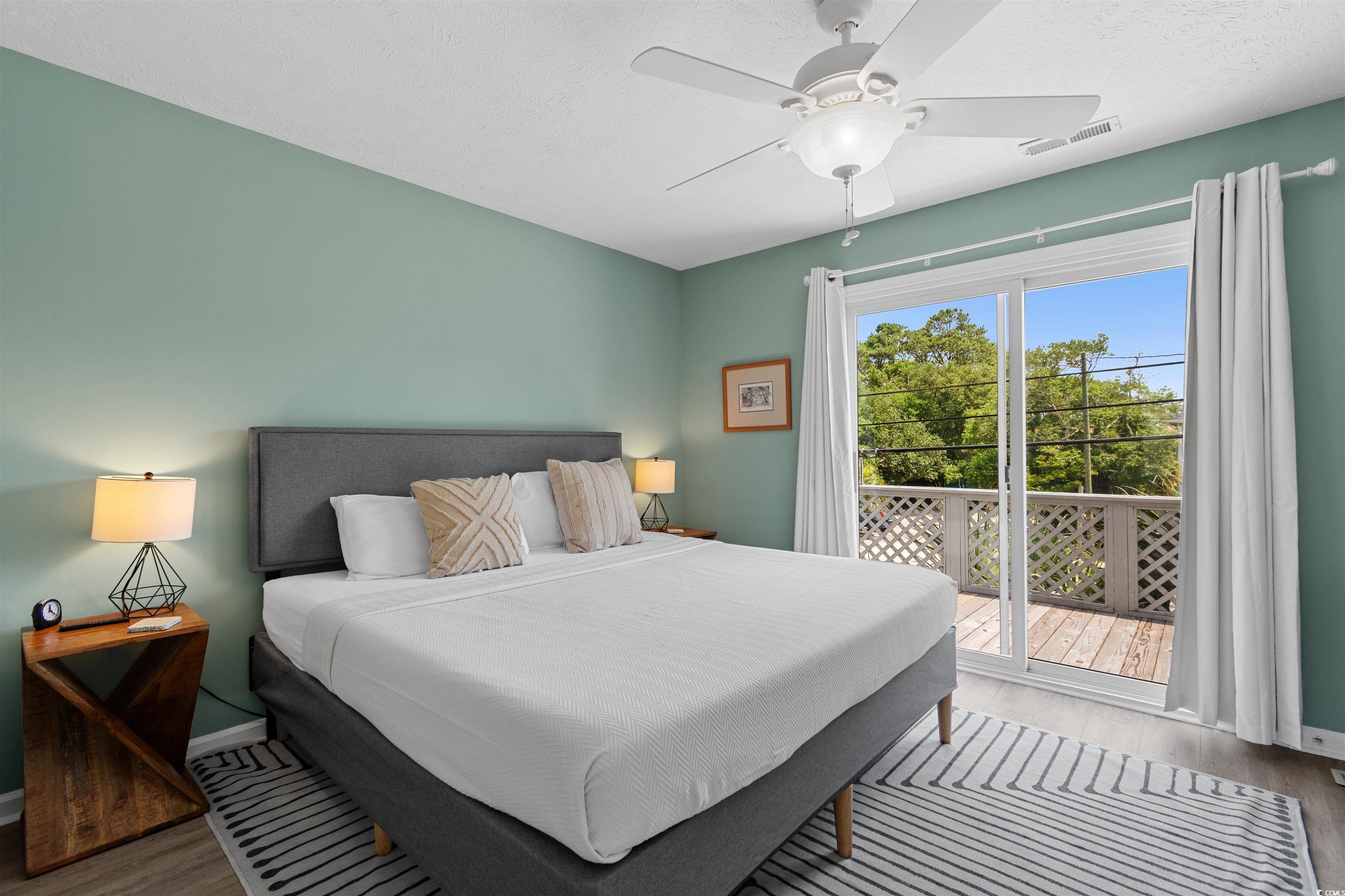 605 A 17th Avenue South North Myrtle Beach, SC 29582 - Photo 25 of 36 Bedroom with wood finished floors, access to exterior, ceiling fan, and a textured ceiling
