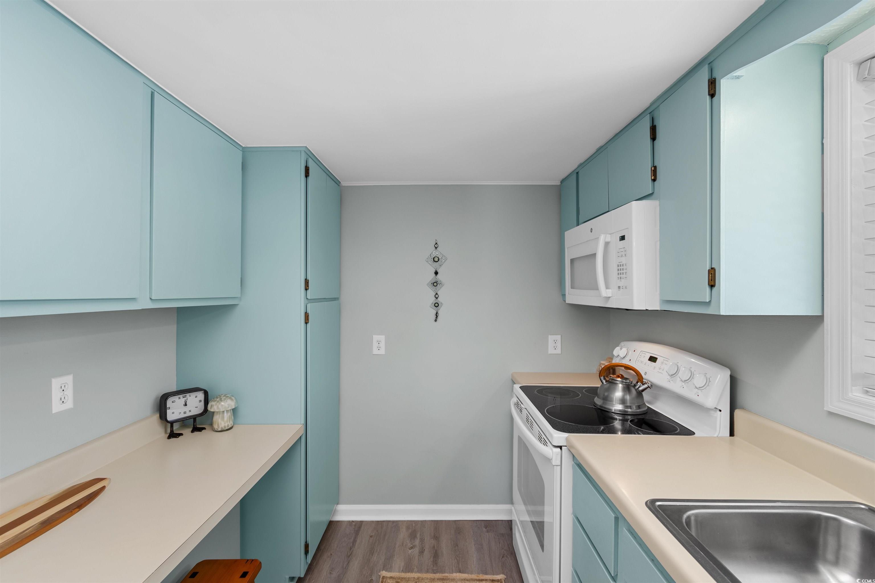 605 A 17th Avenue South North Myrtle Beach, SC 29582 - Photo 3 of 36 Kitchen featuring white appliances, blue cabinets, dark wood-type flooring, and light countertops