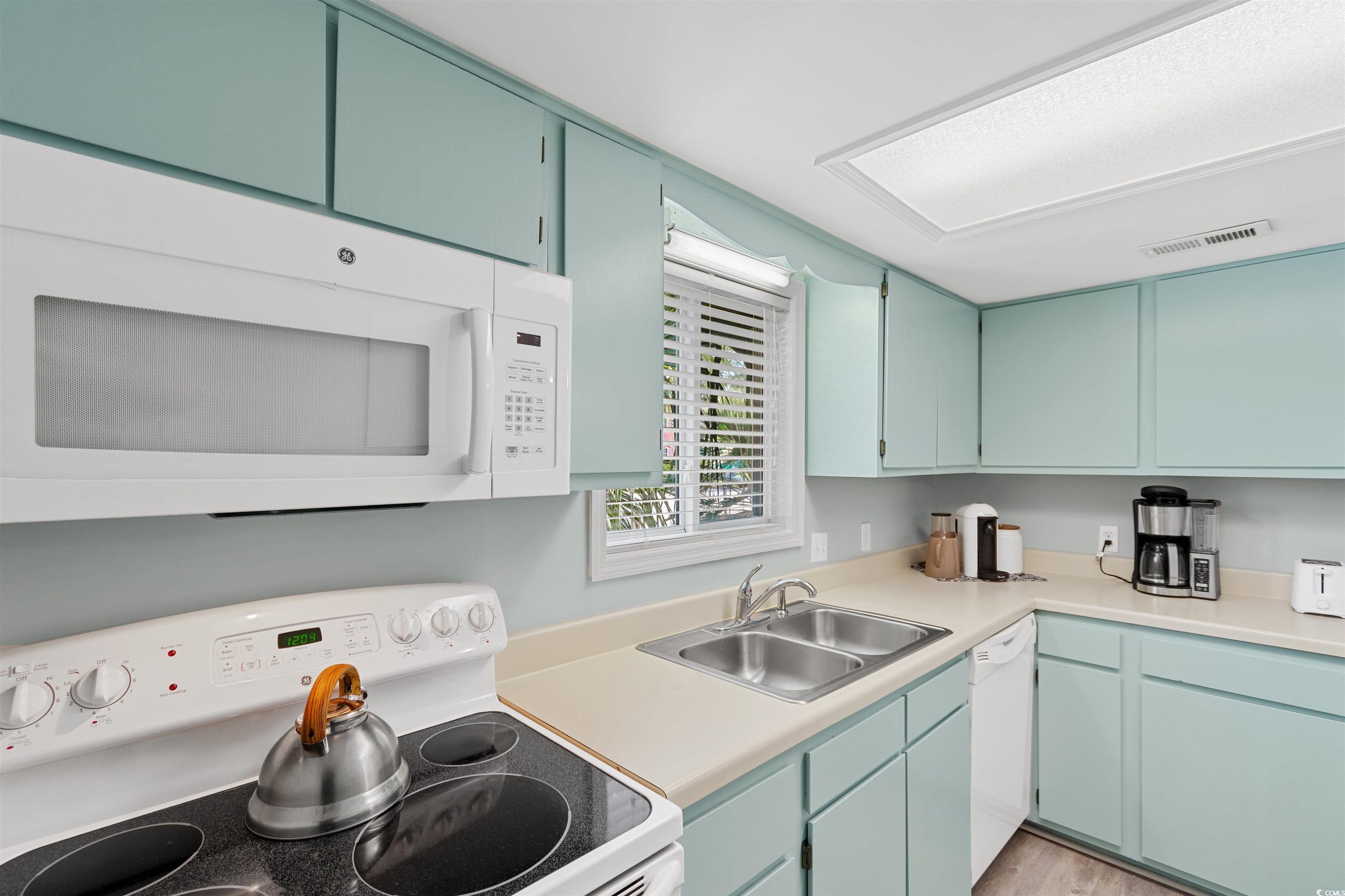 605 A 17th Avenue South North Myrtle Beach, SC 29582 - Photo 6 of 36 Kitchen with white appliances, light countertops, and blue cabinets