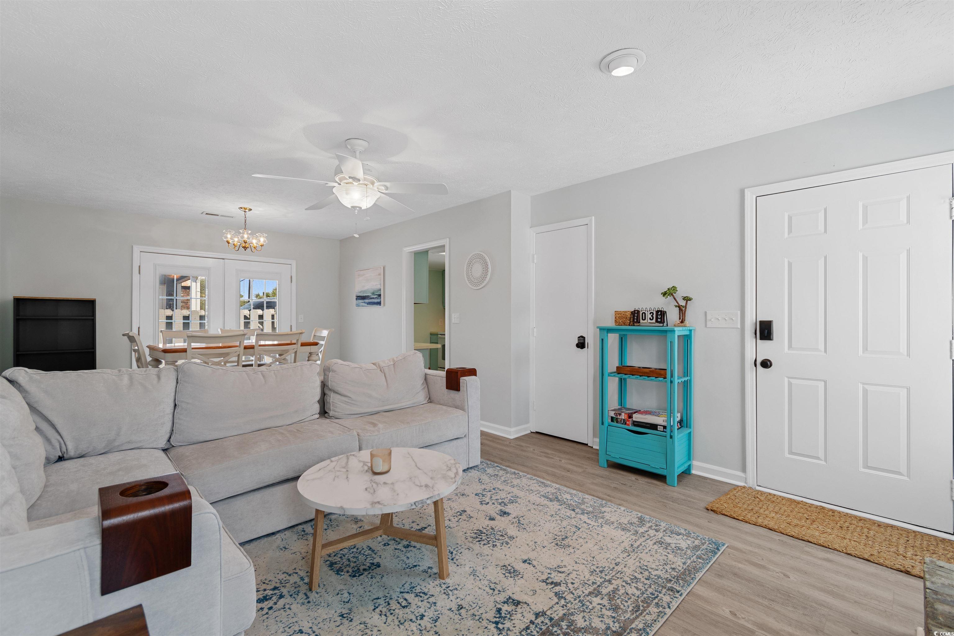 605 A 17th Avenue South North Myrtle Beach, SC 29582 - Photo 10 of 36 Living area with light wood-style floors, a ceiling fan, and a chandelier