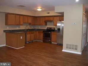 a kitchen with granite countertop a refrigerator and a stove top oven