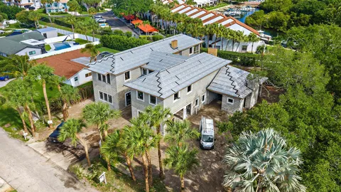 an aerial view of a residential houses with outdoor space and street view