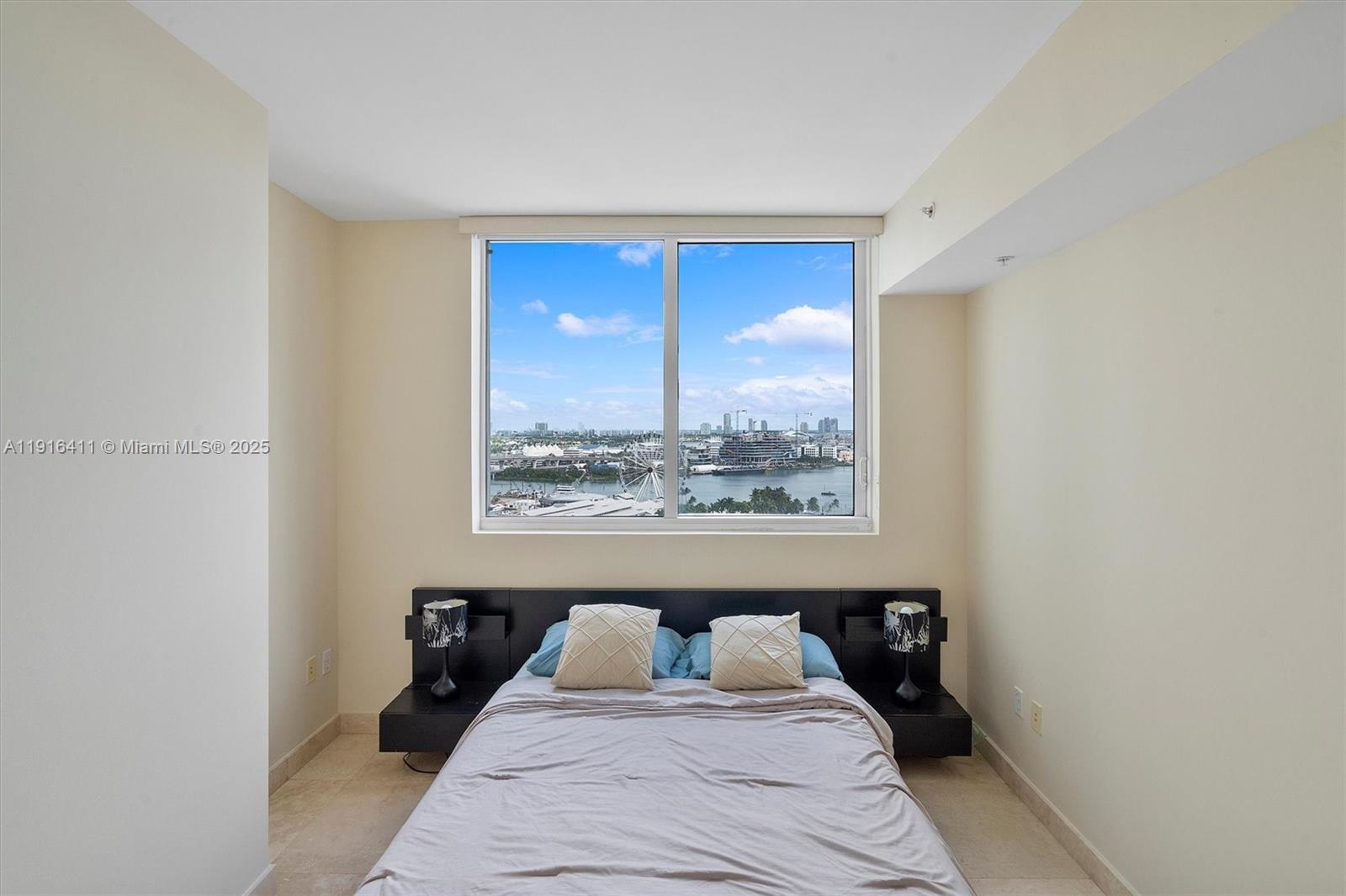 253 Northeast 2nd Street, Unit 1803 Miami, FL 33132 - Photo 11 of 23 a bedroom with a large bed and a large window