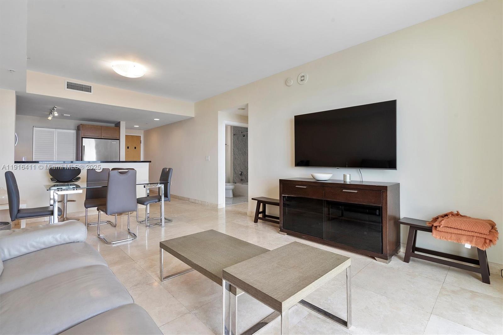 253 Northeast 2nd Street, Unit 1803 Miami, FL 33132 - Photo 6 of 23 a living room with furniture and a flat screen tv