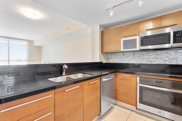 a kitchen with stainless steel appliances granite countertop a sink and a microwave