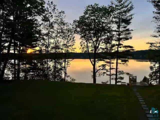 2000 West Chub Lake Road Carlton, MN 55718 - Photo 26 of 30 Expansive lawn leading to a waterfront deck, surrounded by mature trees, with a stone pathway