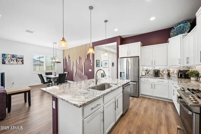 a kitchen with granite countertop a sink refrigerator and cabinets
