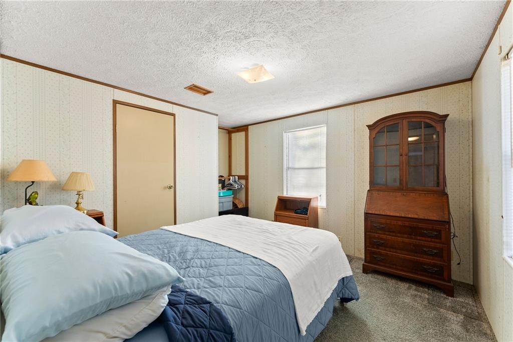 347 Norma Road Dawsonville, GA 30534 - Photo 14 of 33 a bedroom with a bed and a dresser next to a window