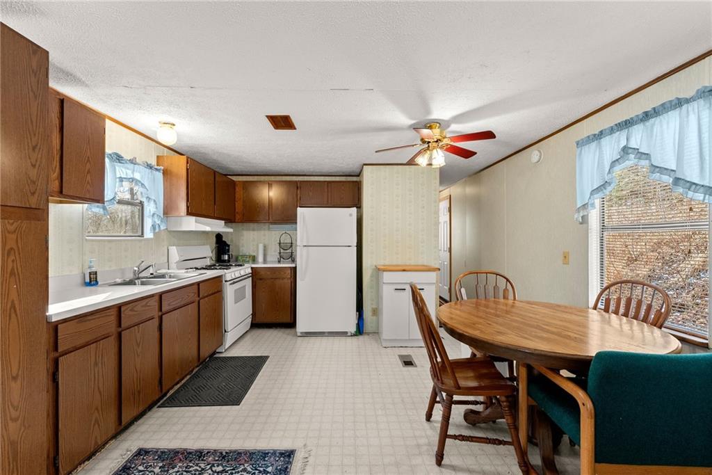 347 Norma Road Dawsonville, GA 30534 - Photo 8 of 33 a kitchen with stainless steel appliances kitchen island granite countertop a table chairs in it and wooden floors