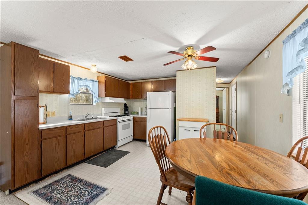 347 Norma Road Dawsonville, GA 30534 - Photo 9 of 33 a kitchen with stainless steel appliances granite countertop a sink dishwasher a stove a refrigerator with a dining table and chairs