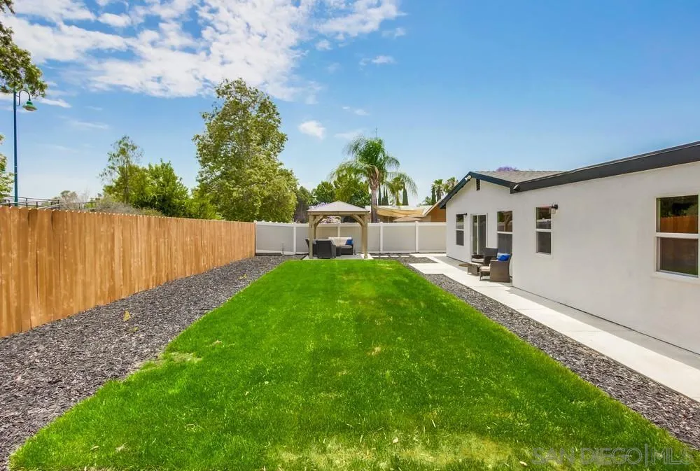 8348 Rumson Drive Santee, CA 92071 - Photo 45 of 53 a backyard of a house with table and chairs plants and large tree