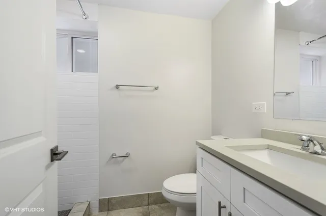a bathroom with a granite countertop sink a toilet and a mirror
