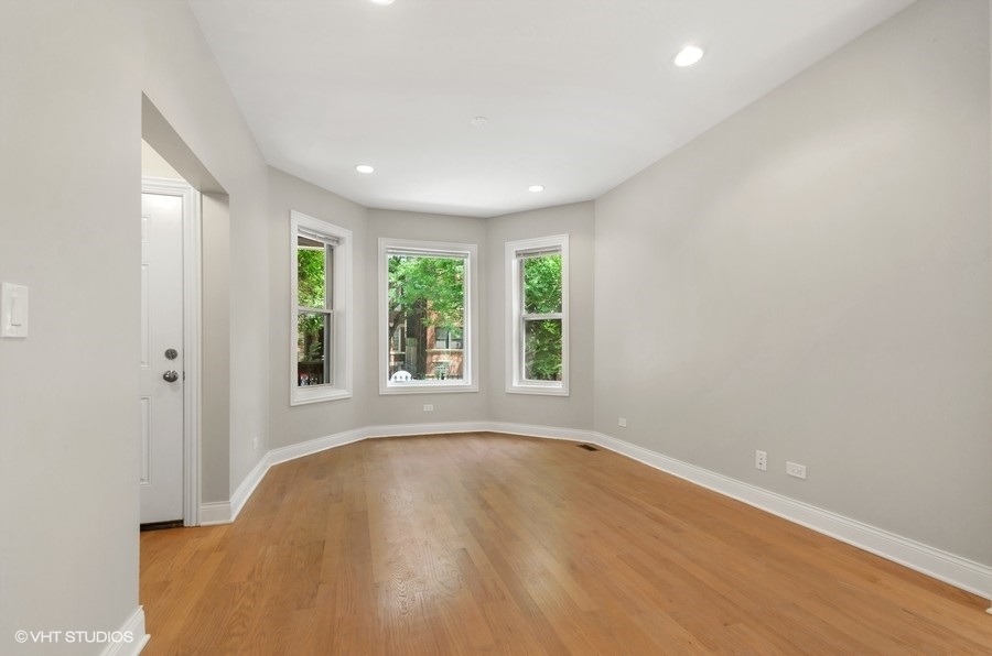 5816 North Ridge Avenue, Unit 1F Chicago, IL 60660 - Photo 3 of 18 an empty room with wooden floor and windows