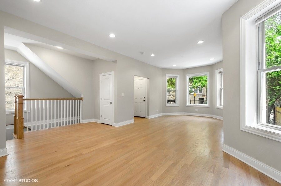 5816 North Ridge Avenue, Unit 1F Chicago, IL 60660 - Photo 5 of 18 an empty room with wooden floor and windows
