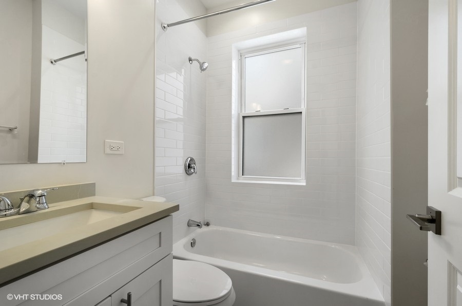 5816 North Ridge Avenue, Unit 1F Chicago, IL 60660 - Photo 6 of 18 a bathroom with a granite countertop sink toilet and shower
