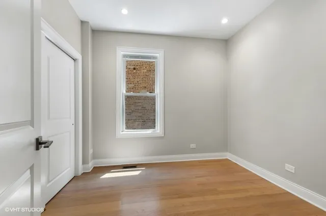 an empty room with wooden floor and a window