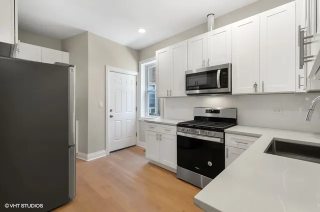 a kitchen with a sink a stove and cabinets