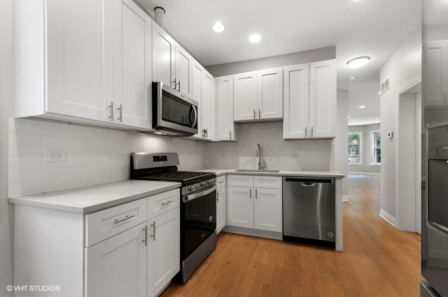 5816 North Ridge Avenue, Unit 1F Chicago, IL 60660 - Photo 10 of 18 a kitchen with stainless steel appliances granite countertop a stove a sink and a microwave