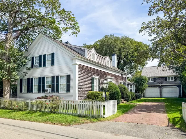 a front view of a house with a garden and plants