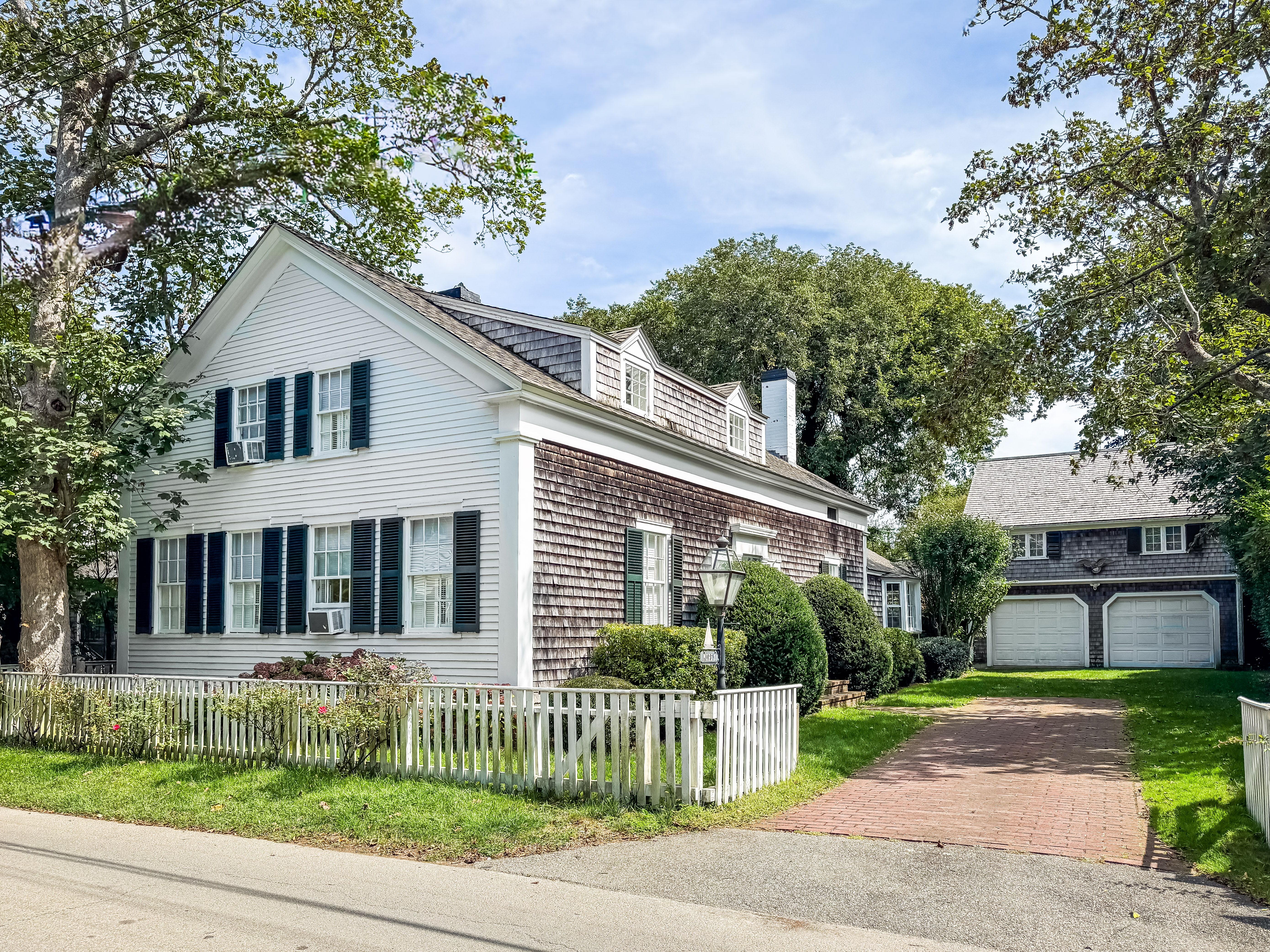 a front view of a house with a garden and plants