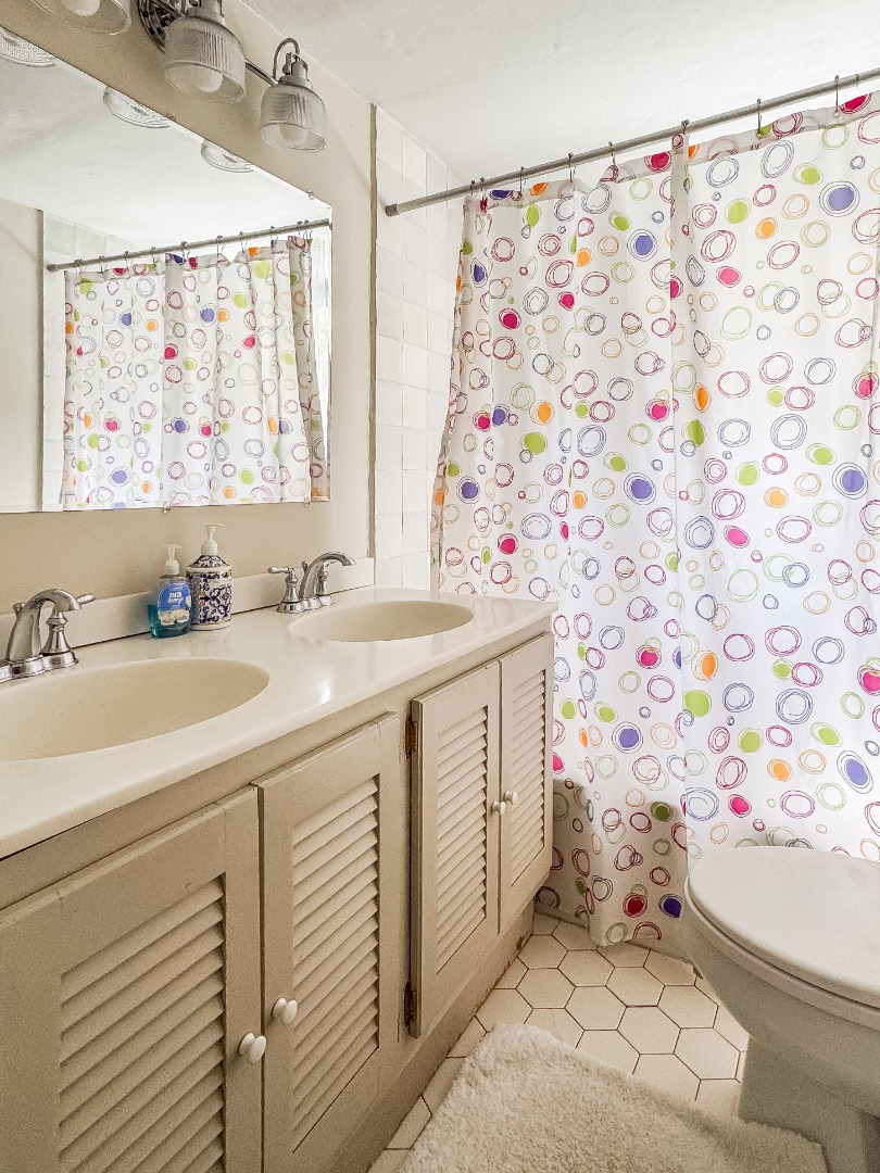 69 School Street Edgartown, MA 02539 - Photo 13 of 23 a bathroom with a sink mirror vanity and toilet
