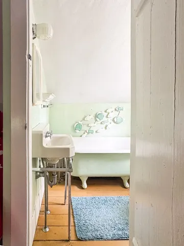 a backyard of a house with table and chairs under an umbrella