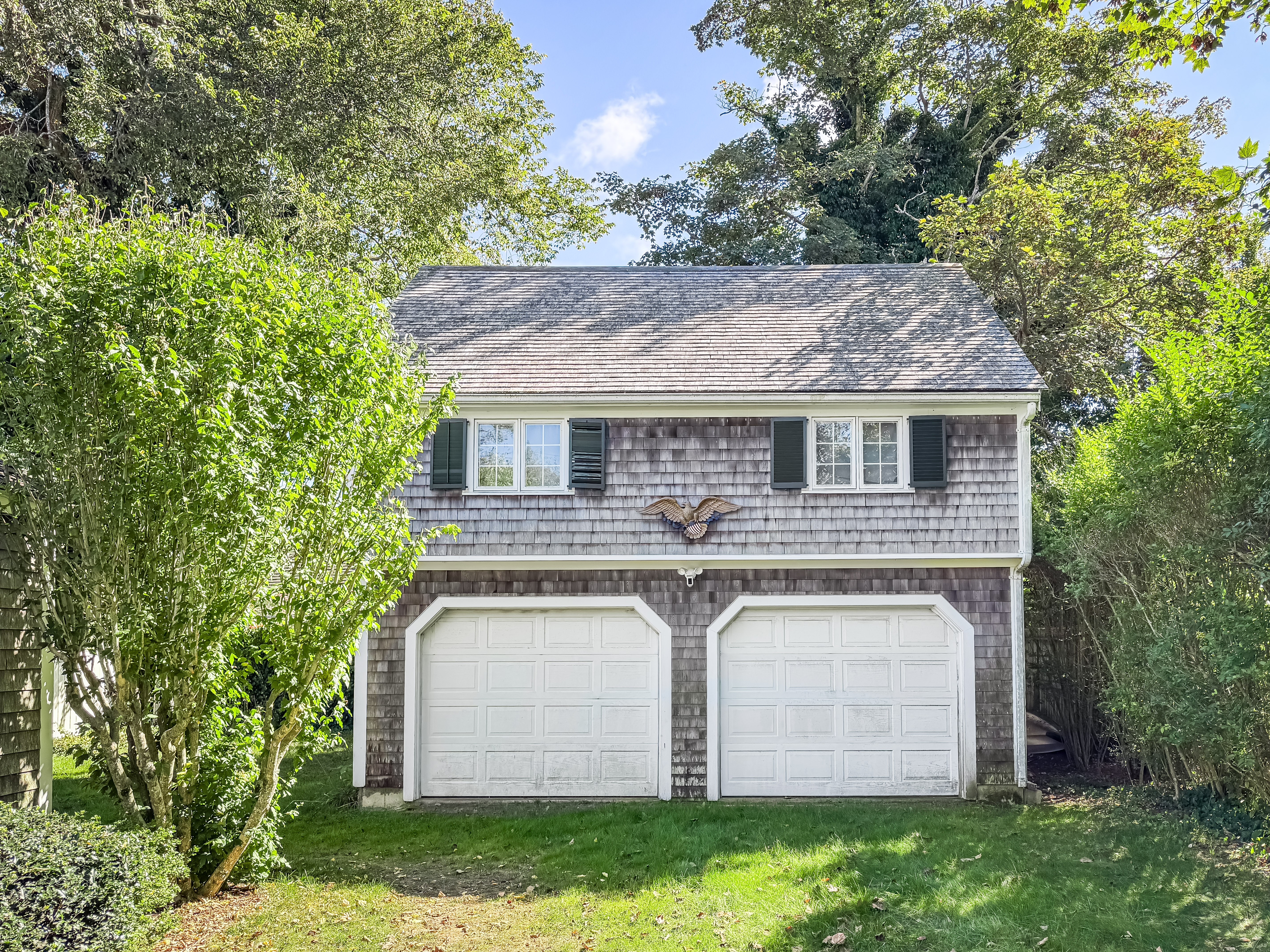 69 School Street Edgartown, MA 02539 - Photo 17 of 23 a front view of a house with a garden and plants