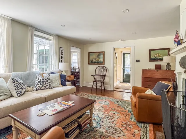 a living room with furniture a rug and a window