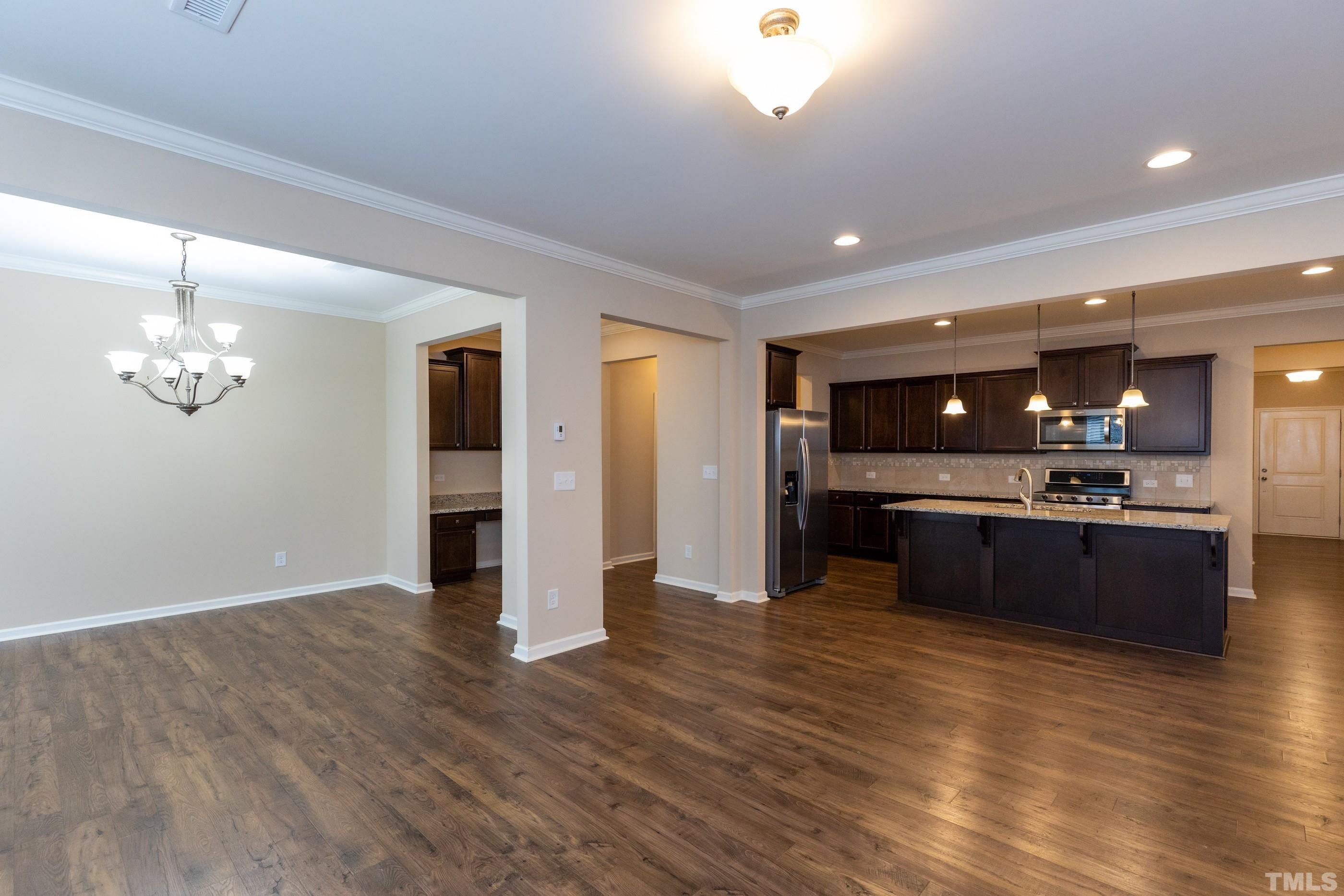 566 Chessie Station Apex, NC 27502 - Photo 11 of 29 a large room with stainless steel appliances kitchen island wooden floors and view living room