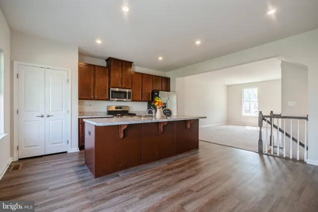 a open kitchen with wooden floor and stainless steel appliances