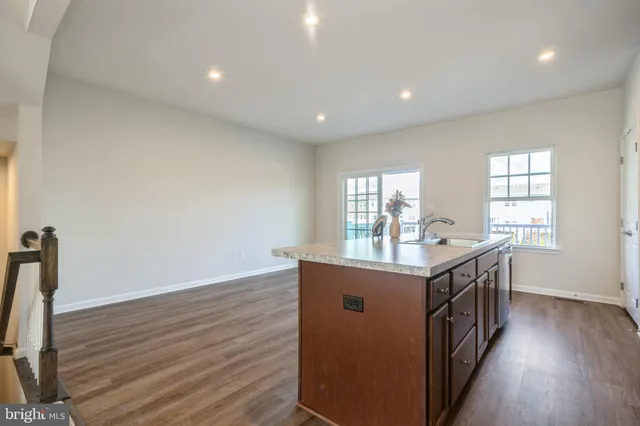 a kitchen with counter top space and wooden floor
