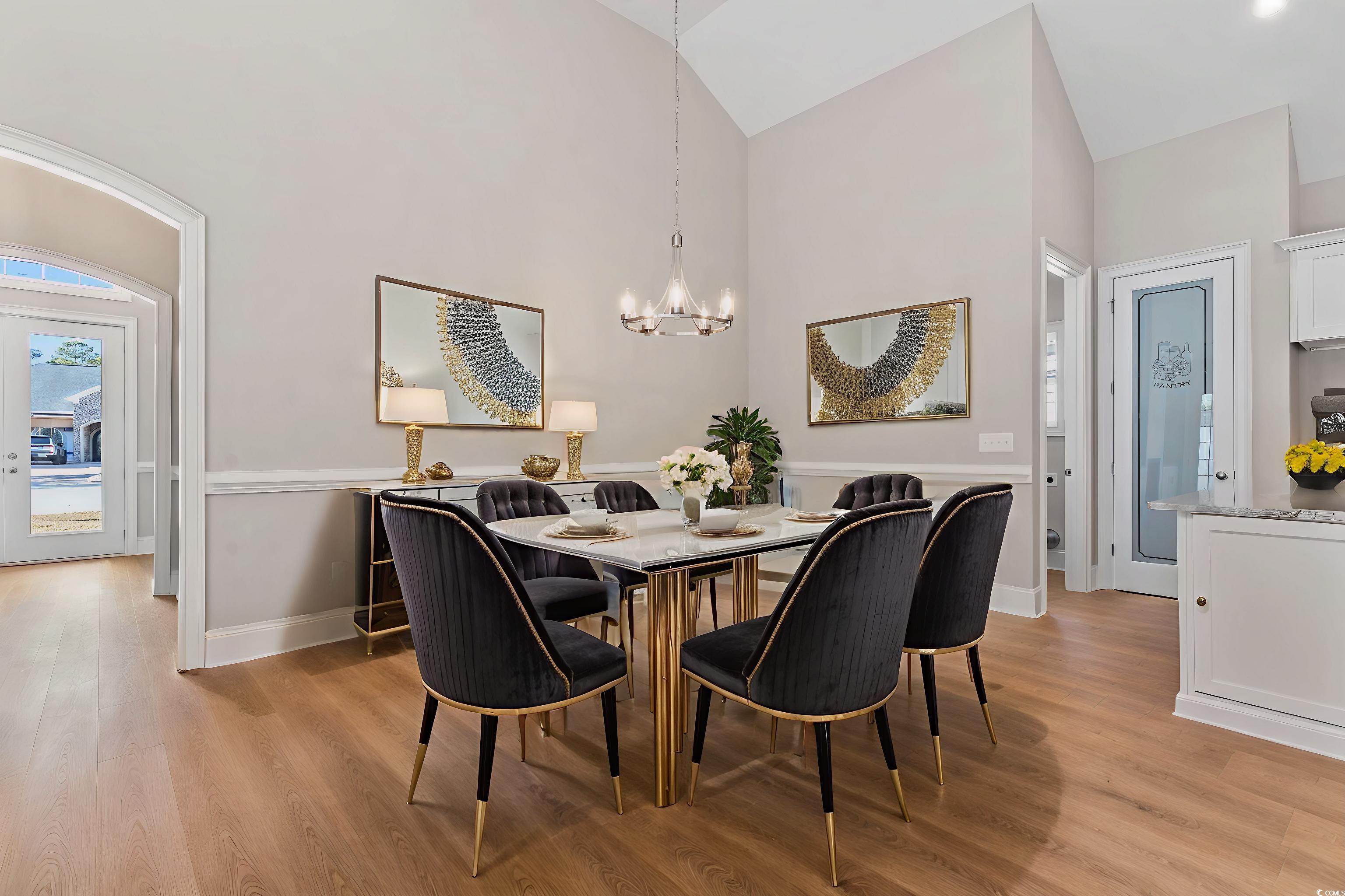 329 Waterfall Circle Little River, SC 29566 - Photo 11 of 39 Dining space featuring light wood-style floors, a chandelier, high vaulted ceiling, and arched walkways