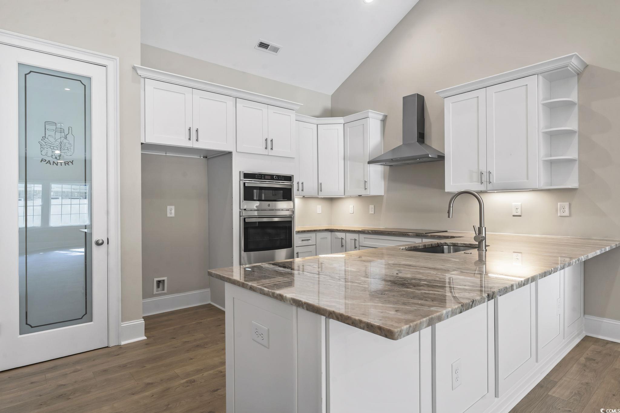 329 Waterfall Circle Little River, SC 29566 - Photo 14 of 39 Kitchen with open shelves, a peninsula, wall chimney range hood, white cabinets, and dark wood-style flooring