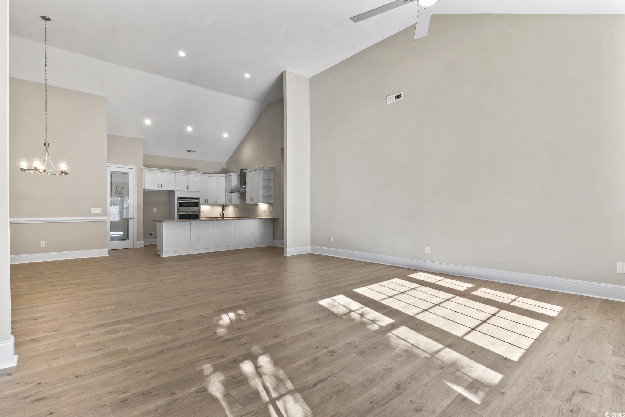 329 Waterfall Circle Little River, SC 29566 - Photo 18 of 39 Unfurnished living room featuring high vaulted ceiling, light wood-type flooring, a chandelier, recessed lighting, and a ceiling fan