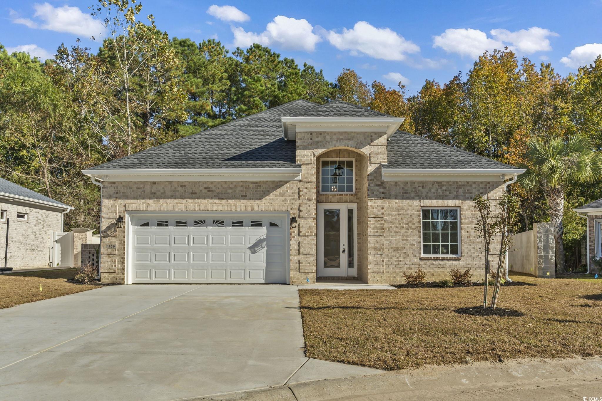 329 Waterfall Circle Little River, SC 29566 - Photo 2 of 39 French provincial home with a shingled roof, brick siding, driveway, and an attached garage
