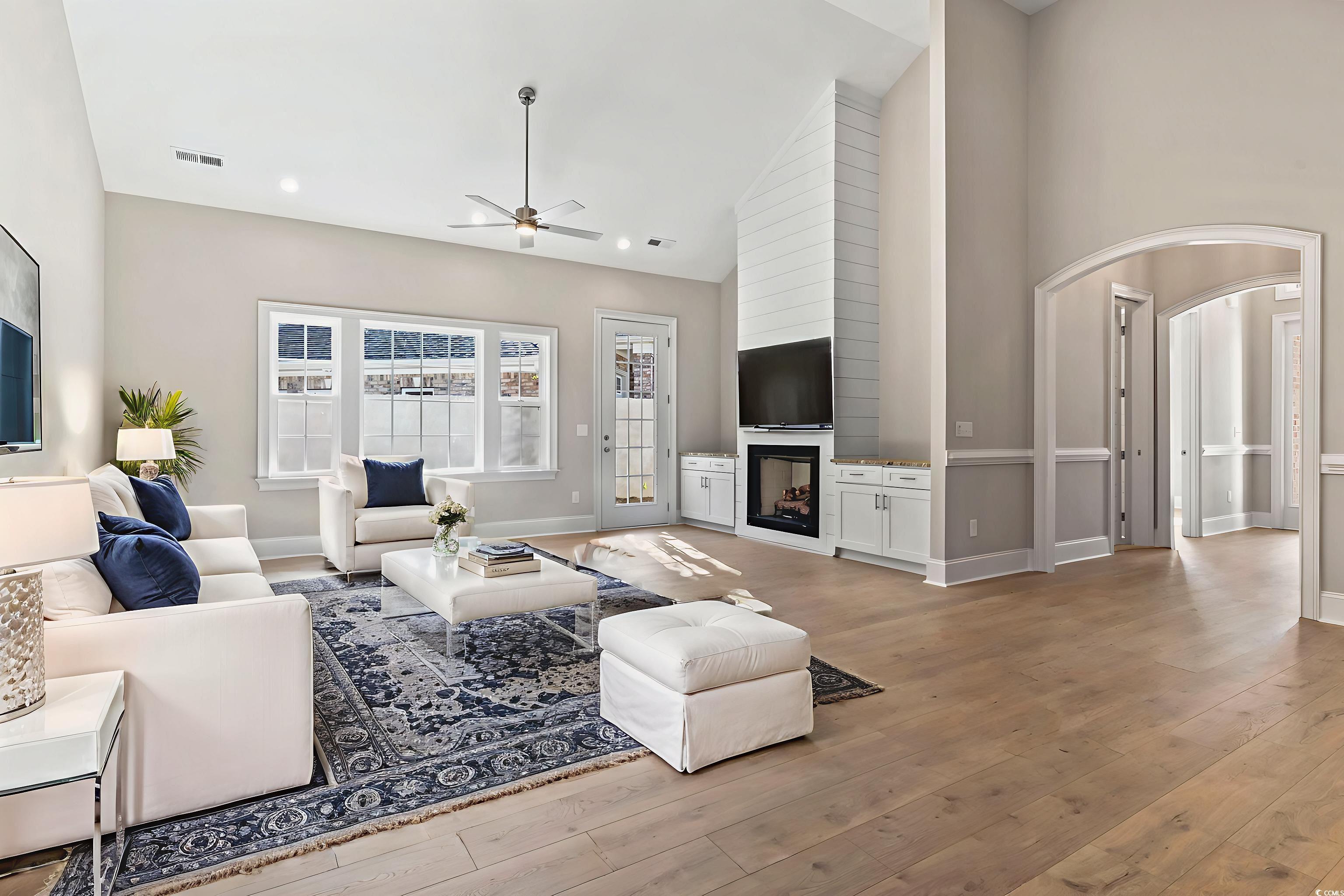 329 Waterfall Circle Little River, SC 29566 - Photo 21 of 39 Living area featuring a large fireplace, a ceiling fan, high vaulted ceiling, arched walkways, and light wood-type flooring