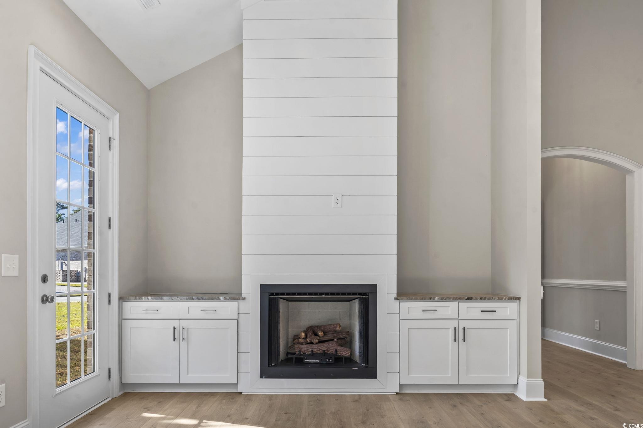 329 Waterfall Circle Little River, SC 29566 - Photo 22 of 39 Unfurnished living room with a large fireplace, light wood-style floors, and lofted ceiling