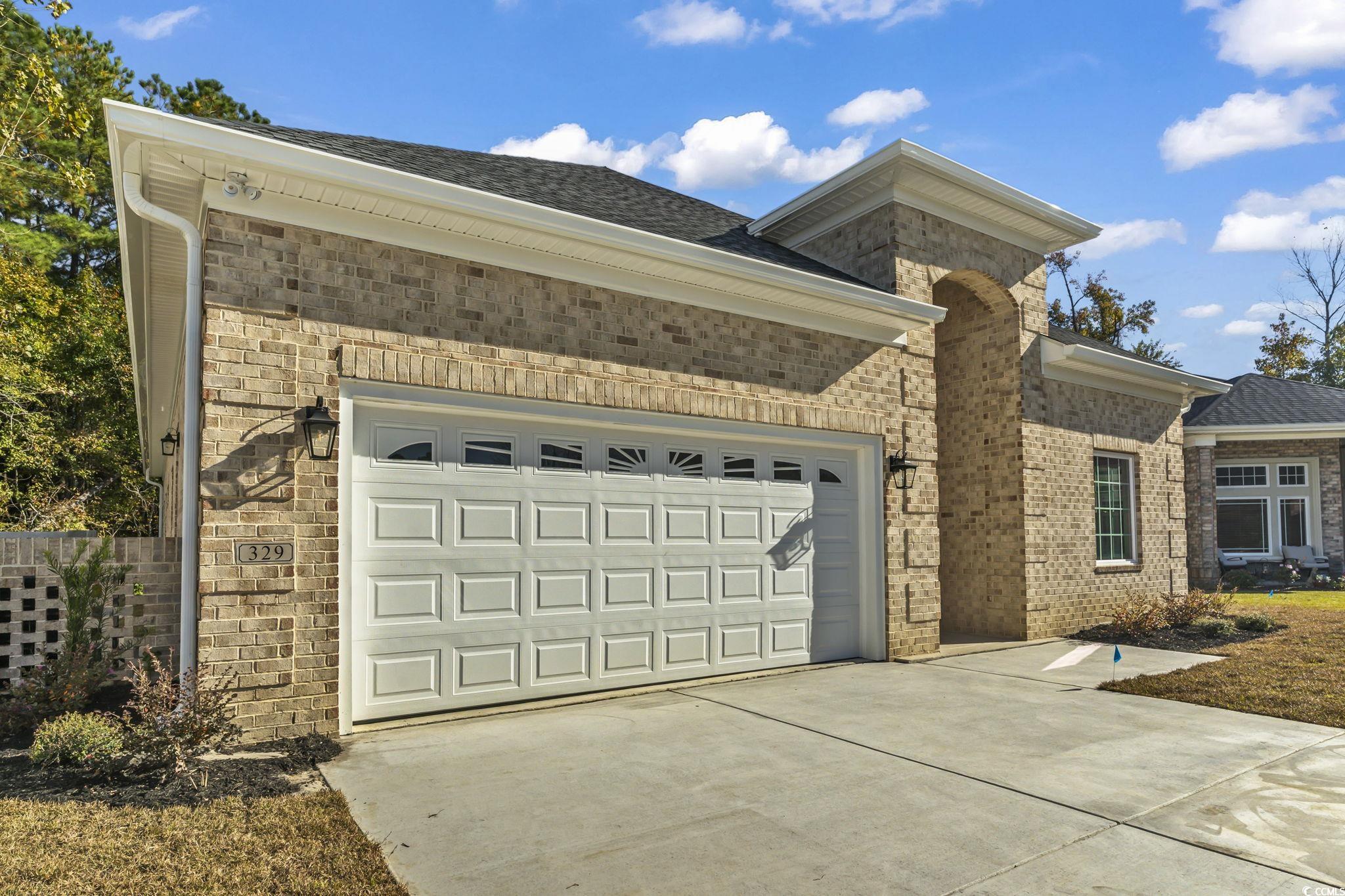 329 Waterfall Circle Little River, SC 29566 - Photo 3 of 39 View of front of property with driveway, an attached garage, brick siding, and roof with shingles