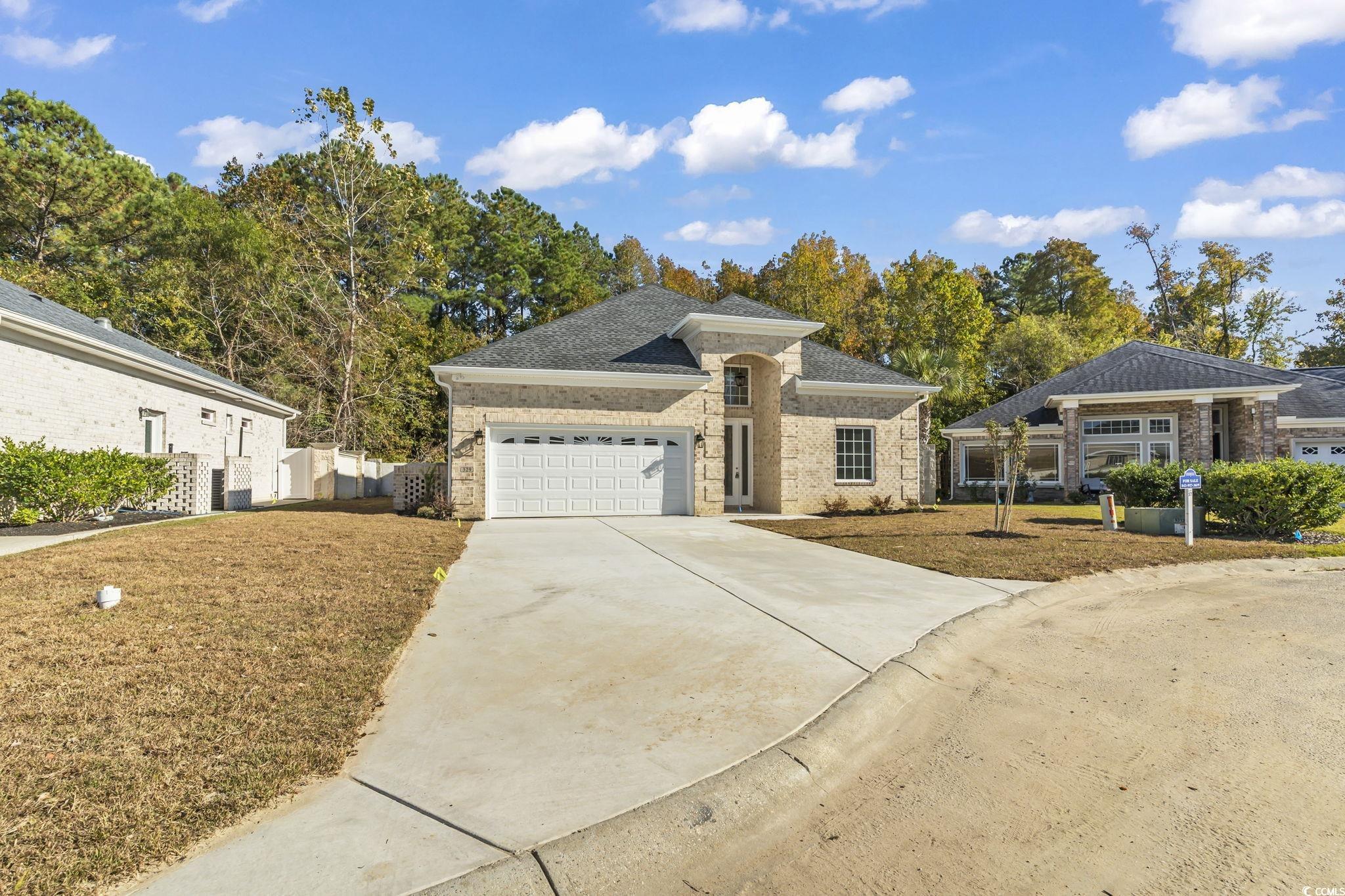 329 Waterfall Circle Little River, SC 29566 - Photo 5 of 39 Ranch-style house with concrete driveway, an attached garage, a front yard, brick siding, and a shingled roof