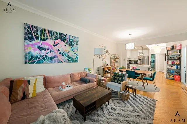 a living room with furniture a rug and wall paintings